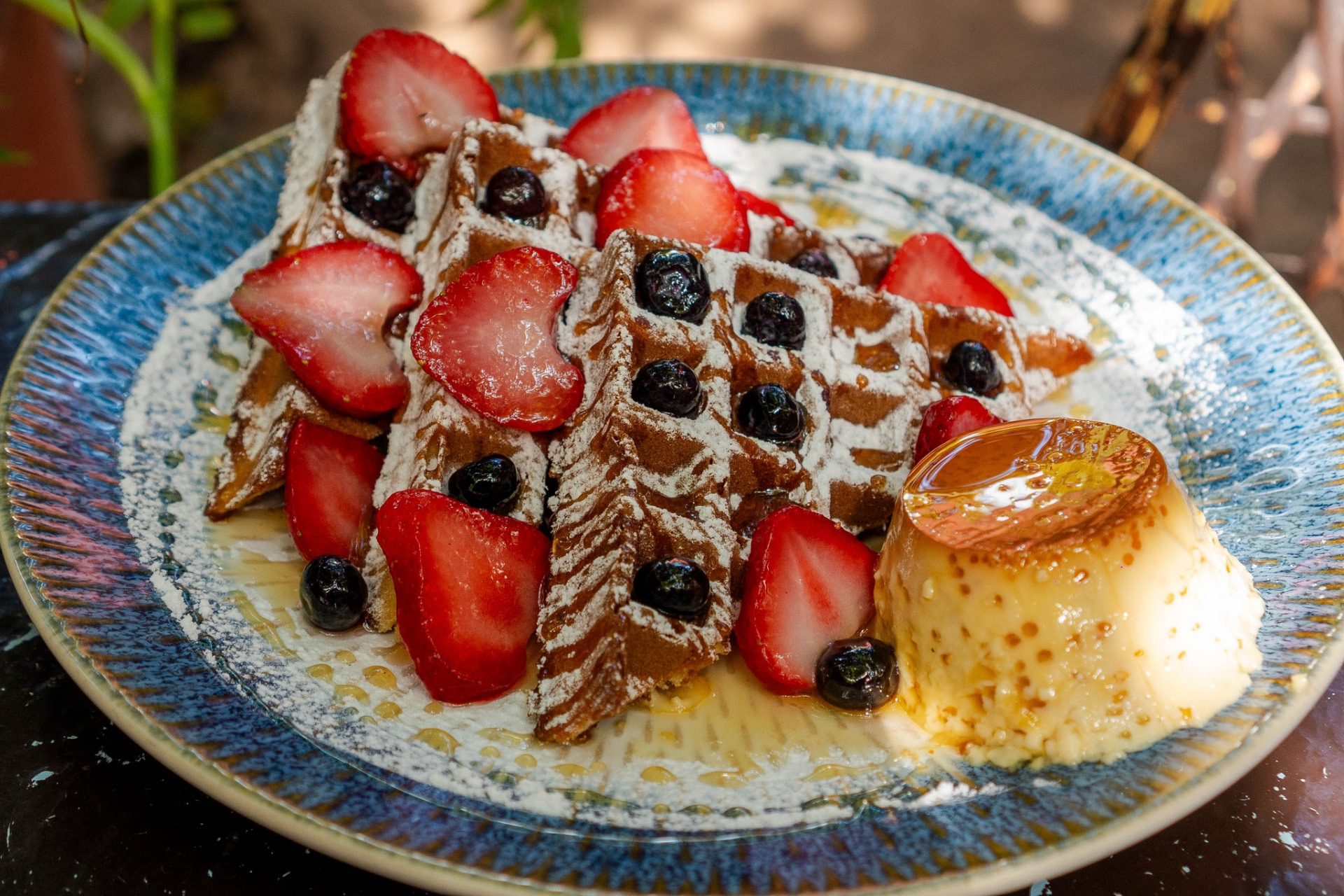 Waffles con fresas, arándanos, azúcar glass y flan artesanal